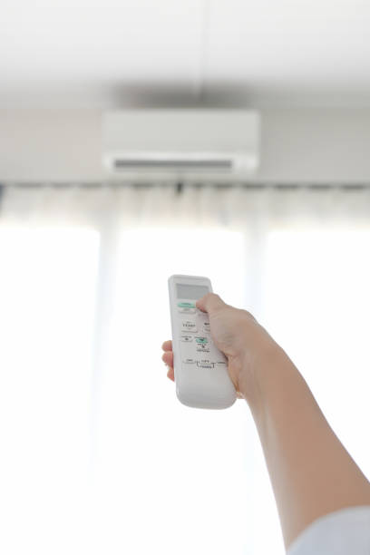istock The housekeeper is using the air conditioner by selecting the image focus on the remote. 1269863135