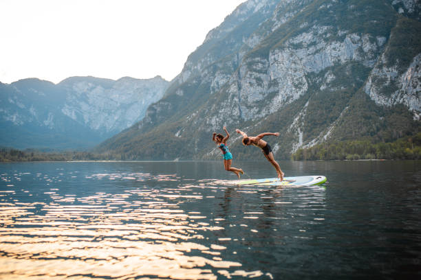istock Vacationing Couple Jumping Off Paddleboard into Lake Bohinj 1269865218
