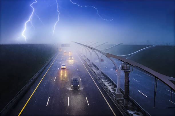 coches que circulan por una carretera bajo una lluvia torrencial con una tormenta eléctrica - lightning thunderstorm city storm fotografías e imágenes de stock