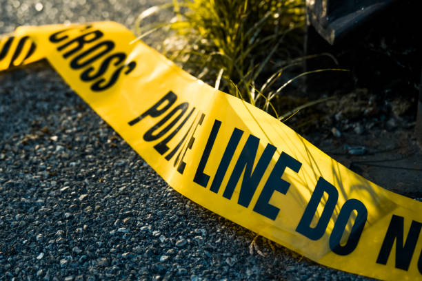 Police tape on the floor at a night crime scene Night shoot of investigating evidence at the crime scene sealed with police barricade tape.  4K resolution video footage. gun laws stock pictures, royalty-free photos & images