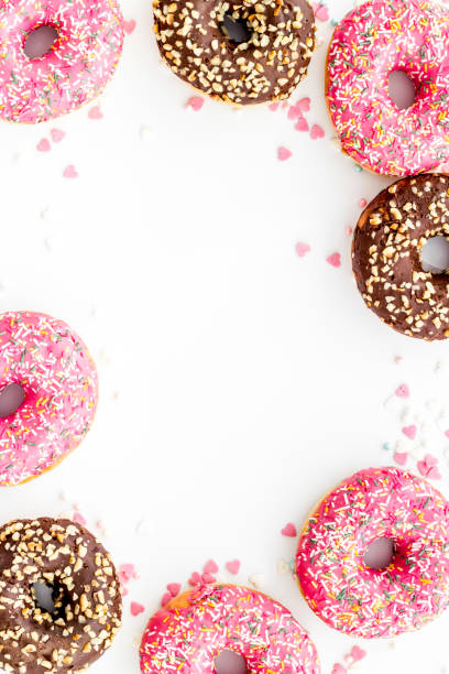 istock Frame of donuts with icing and sprinkles, overhead view. Colorful bakery 1269872273