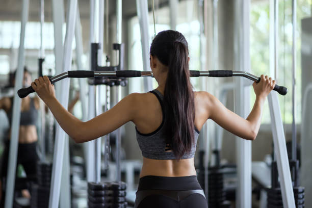 istock Woman pump back by machine in gym 1269875464