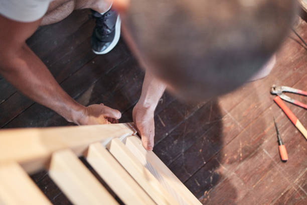 istock Carpenter hobbyist assembling wooden boards at home / garage. 1269876749