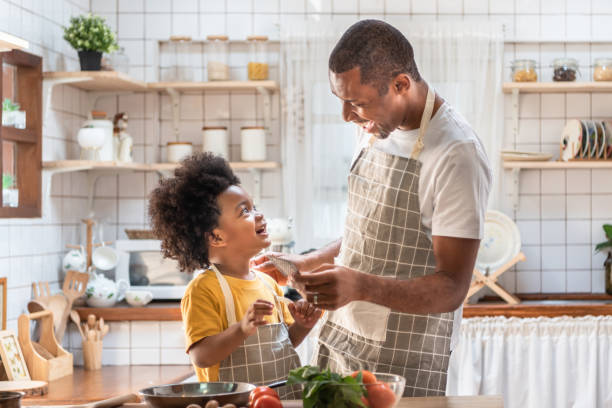 istock African American Father and son laughing while cooking in kitchen 1269878819