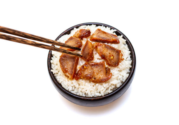 istock White rice with grilled pork in black bowl on white background 1269882126