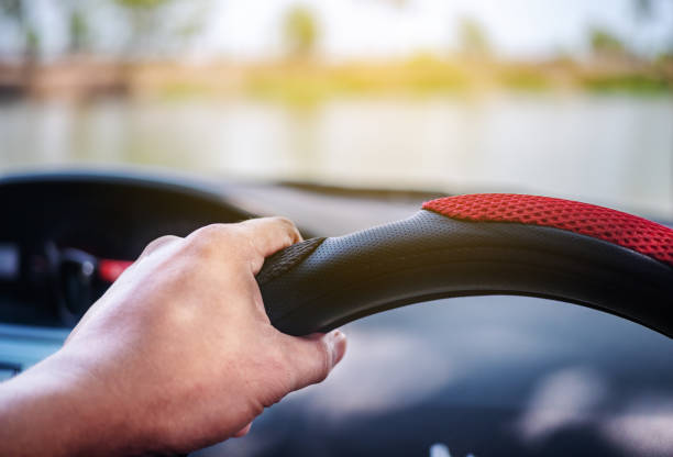 istock Hand driving a car on the road 1269882156