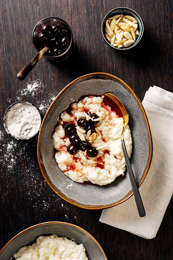 Overhead view of a traditional danish rice pudding or risalamande dessert served at Christmas time in Denmark and in other parts of Scandinavia. It is traditionally served with a rich cherry sauce and chopped almonds. Usually there is a small silver coin hidden in the dessert that one lucky child will hopefully find.