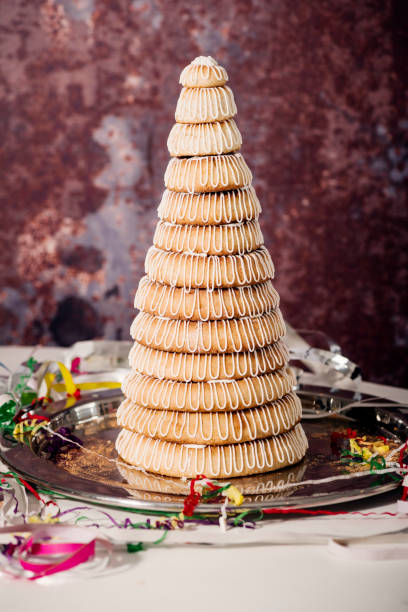 Kransekage for Danish New Year Celebration Kransekage or “Wreath Tower Cake” are typically eaten at a New Years Eve party or occasionally Christmas or maybe even a birthday celebration. They are made of rings of baked marzipan and they are no limits as to how many you can layer up! They are decorated with a simple white icing design usually with flags on the top or silly birthday paper decorations. They can also be made in a more simple rectangular pyramid shape. Please see the rest of my images for other compositions. marzipan stock pictures, royalty-free photos & images