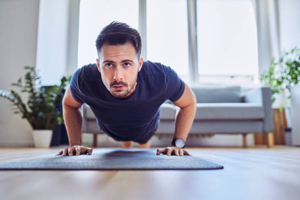 istock Training at home. Closeup of man doing pushups at home 1269882600