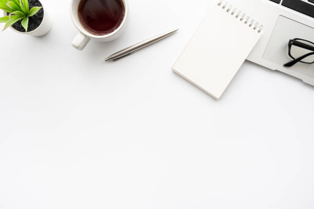 istock White office desk table with small blank notebook, laptop computer cup of coffee and office supplies. Top view with copy space, flat lay. 1269882639