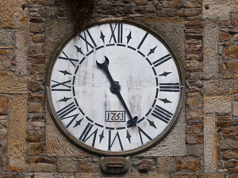 Old clock on the facade of an abandoned and ruined church.
