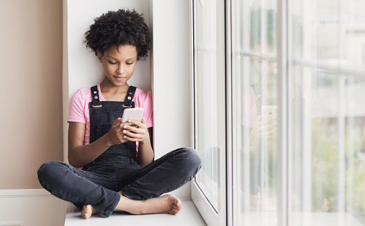 Teenager texting on mobile phone at home. Communication online, technology, people, children lifestyle concept