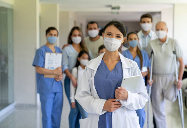 病院でフェイスマスクを着用した患者のグループを率いる医師 - patient medical occupation cheerful latin american and hispanic ethnicity ストックフォトと画像