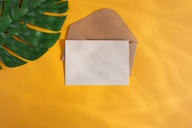 istock Paper konyert and green monstera leaf on a warm orange background. Flat workplace. Top view, with empty space for text. 1269894243