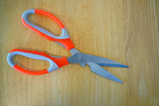 Close-up Orange scissors on wooden background