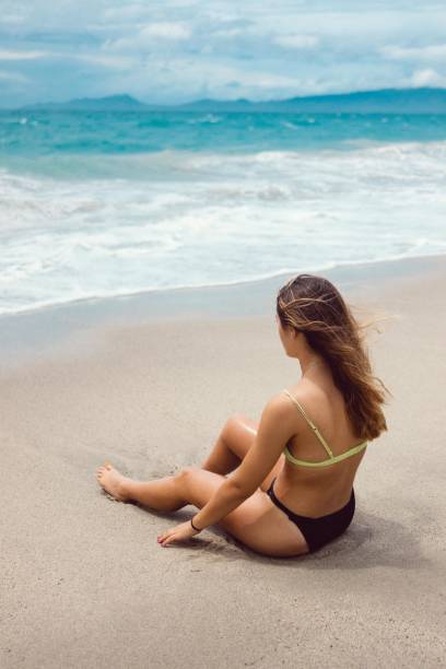 istock Girl sitting by the shore 1269899781
