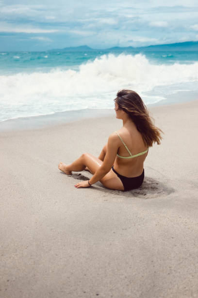 istock Girl sitting by the shore 1269899812