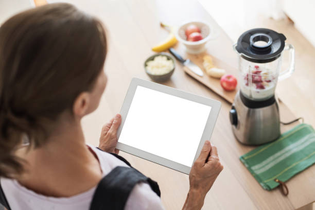 istock Woman preparing food following recipe using digital tablet 1269900471