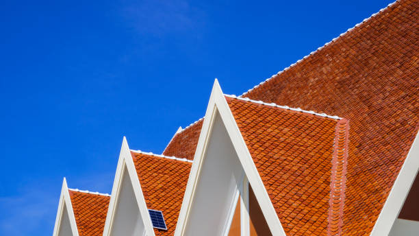 angolo basso e vista laterale di 3 tetti a timpano con un piccolo pannello solare in cima al padiglione tradizionale tailandese sullo sfondo del cielo blu - gable top tall foto e immagini stock