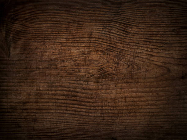 istock old scratched dark wooden board background 1269902295