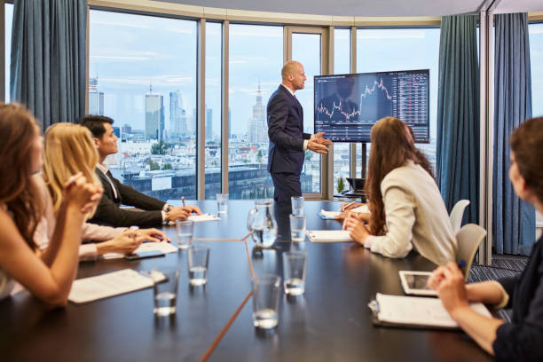 istock Businessman explaining growth of sales graph, reporting about good result, motivating workers. Multi ethnic team in board room 1269902332