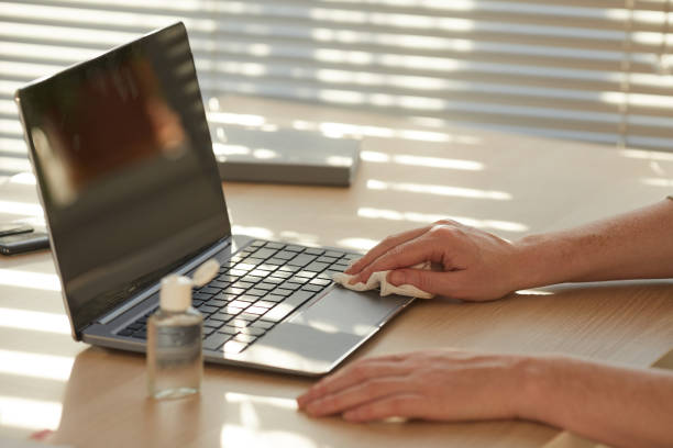 istock Woman Sanitizing Laptop at Workplace Closeup 1269902743