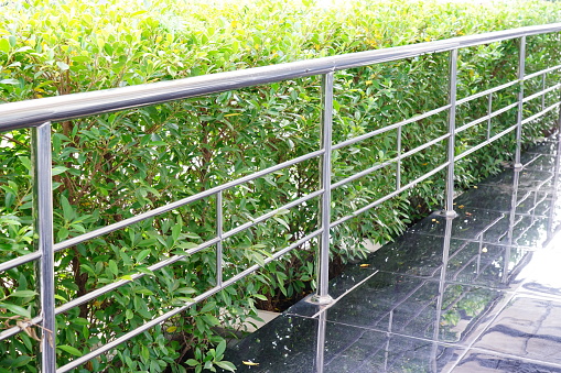 Outdoor Stainless steel fence handrail on green background