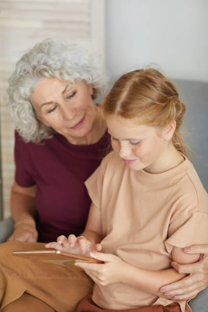 istock Senior Woman Using Tablet with Girl 1269904268