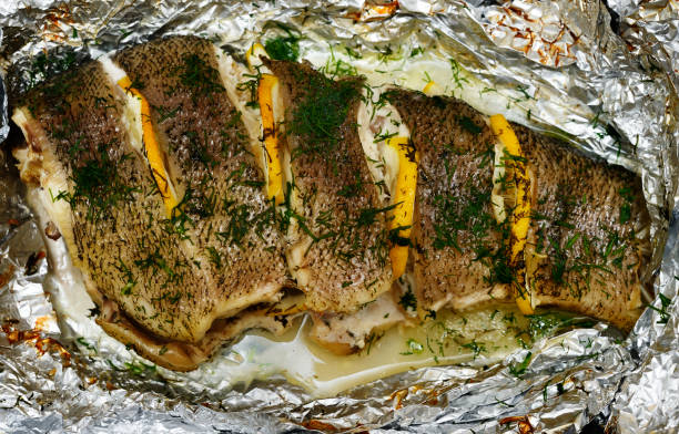 baked fish with lemon and dill on foil baked fish with lemon and dill on foil tinca tinca stock pictures, royalty-free photos & images