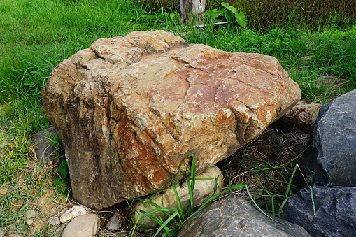 Large stones are on the grass in the garden.