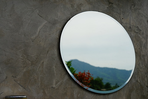 Close-up mirror on concrete wall background