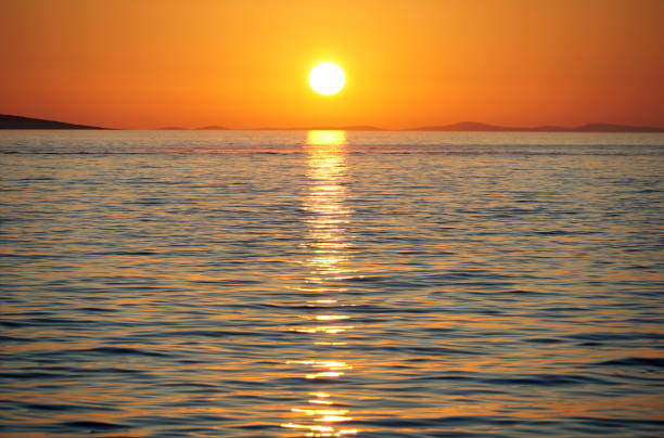 istock Beautiful orange sundown above wavy blue sea water 1269908501