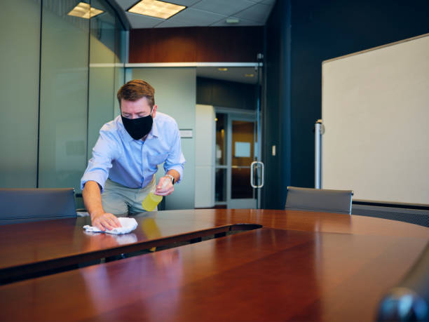 istock Office Worker Cleaning and Sanitizing a Conference Room 1269909778