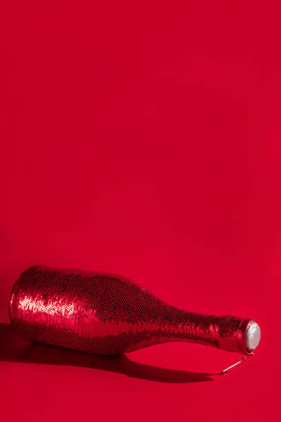 istock Modern design template with champaigne bottle covered in red sequines on red background. Christmas background concept. Holiday celebration concept. 1269916081