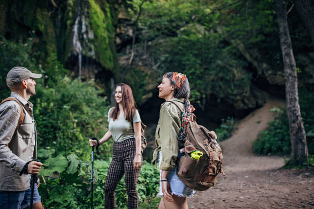 istock Three hikers standing near waterfall and talking 1269919817