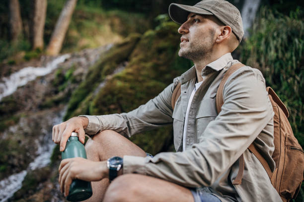 istock Male hiker sitting by the waterfall in nature 1269920941