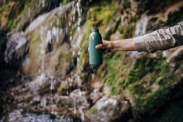 el excursionista rellena su botella de acero inoxidable con agua limpia y fresca - water bottle bottle steel stainless steel fotografías e imágenes de stock