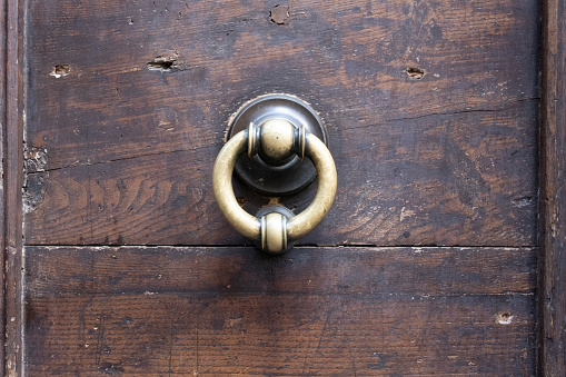 Metal knobs with decorative elements on a old wooden door
