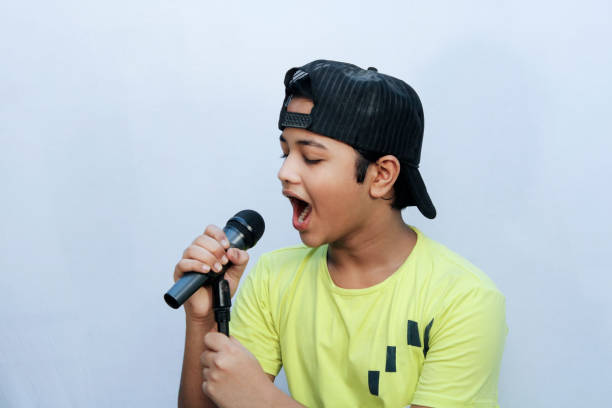 istock A boy trying for sing song and hold dynamic mic in hand and shouting 1269925123
