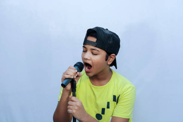 istock A boy trying for sing song and hold dynamic mic in hand and shouting 1269925163