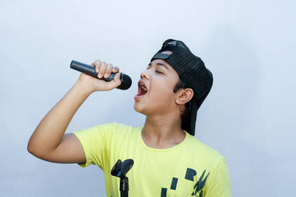 istock A boy trying for sing song and hold dynamic mic in hand and shouting 1269925216