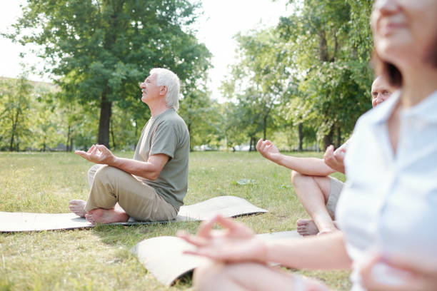 istock Seniors meditating in park 1269927134