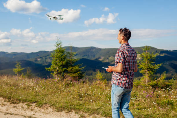 istock Drone remote control. Man operating copter controller in mountains. Aerial video shooting of summer Carpathins 1269931938