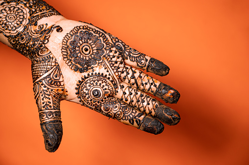 Henna Tattoo or mehendi on an Indian woman's hand. Mehndi, Henna dye is applied on girl's hand during Indian festival of Karva Chauth, Teej, makar sankrati etc. and during their marriage.