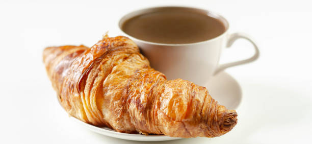 istock Delicious croissant on a ceramic saucer with coffee in a cup, 1269933009