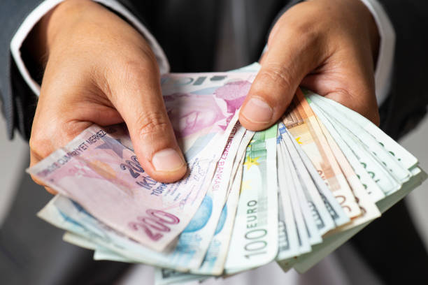 Dollar Euro and Turkish Liras Man in suit holding Dollar, Euro and Turkish Liras banknotes. turkish lira photos stock pictures, royalty-free photos & images