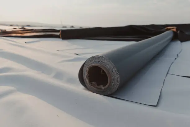 Photo of Roofing PVC membrane in rolls placed on the roof of the site