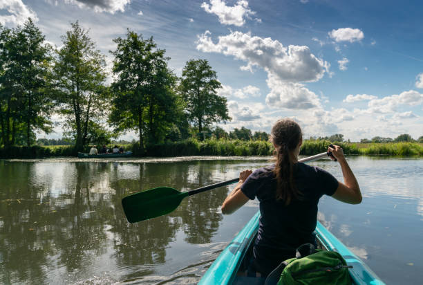 female kayaker enjoys paddling through the channels and canals o the Spreewald region in Germany A female kayaker enjoys paddling through the channels and canals o the Spreewald region in Germany spreewald stock pictures, royalty-free photos & images