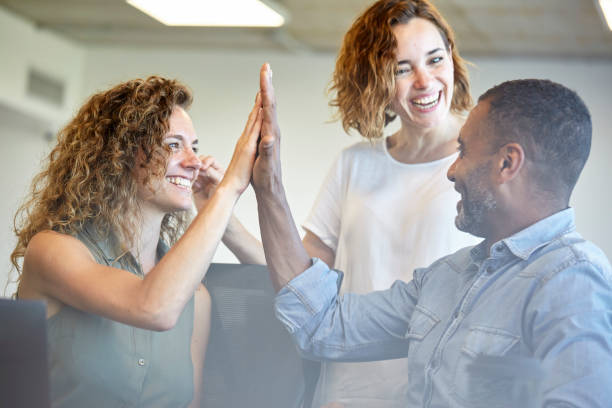 istock Happy business people giving high-five in office 1269942425