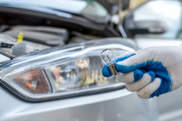 trabajador profesional que cambia nuevo coche de bombillas halógenas - faro luz de vehículo fotografías e imágenes de stock